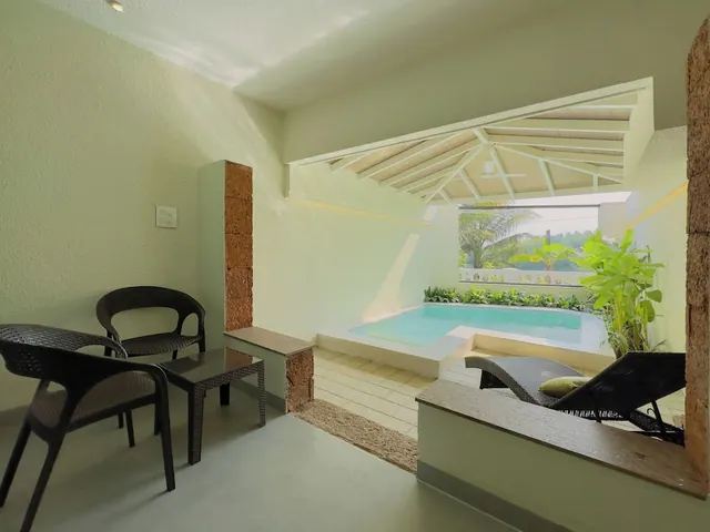 A covered terrace has seating, loungers and a private plunge pool overlooking tropical plants.
