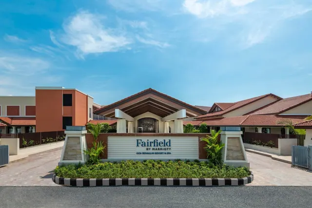 The Fairfield by Marriott Goa Benaulim Resort and Spa entrance is shown from the road with landscaped planting and tiled-roof buildings.