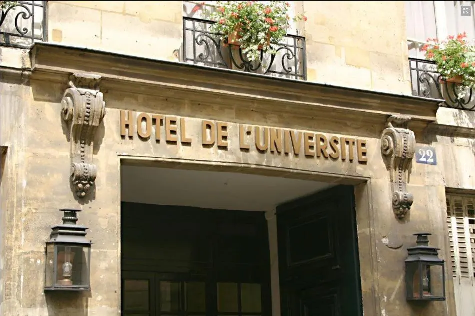 The stone entrance facade of Hotel de l'Universite features wrought-iron flower boxes, carved ornamentation and lanterns.