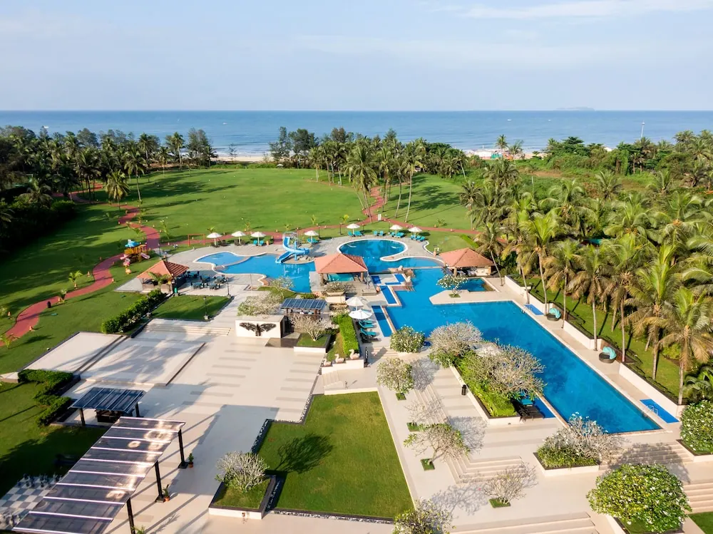 An expansive resort pool complex overlooks tropical gardens and the sea.